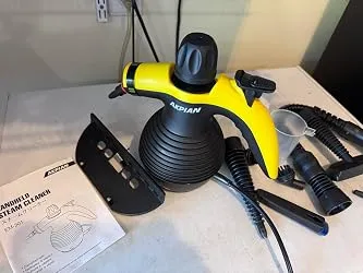 Steam cleaner on a table with window tool, hose and user manual